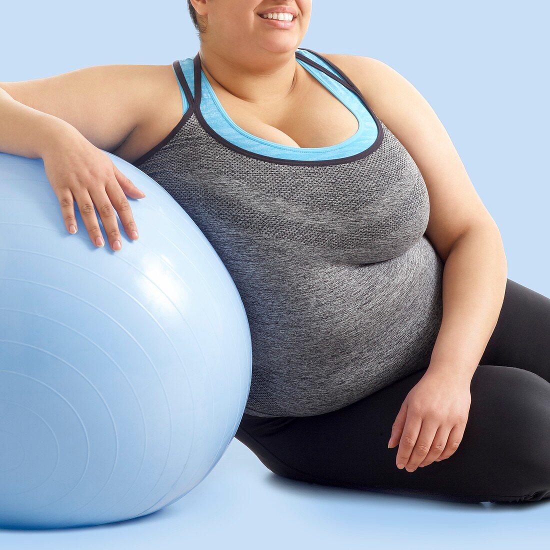 Overweight woman resting on exercise ball