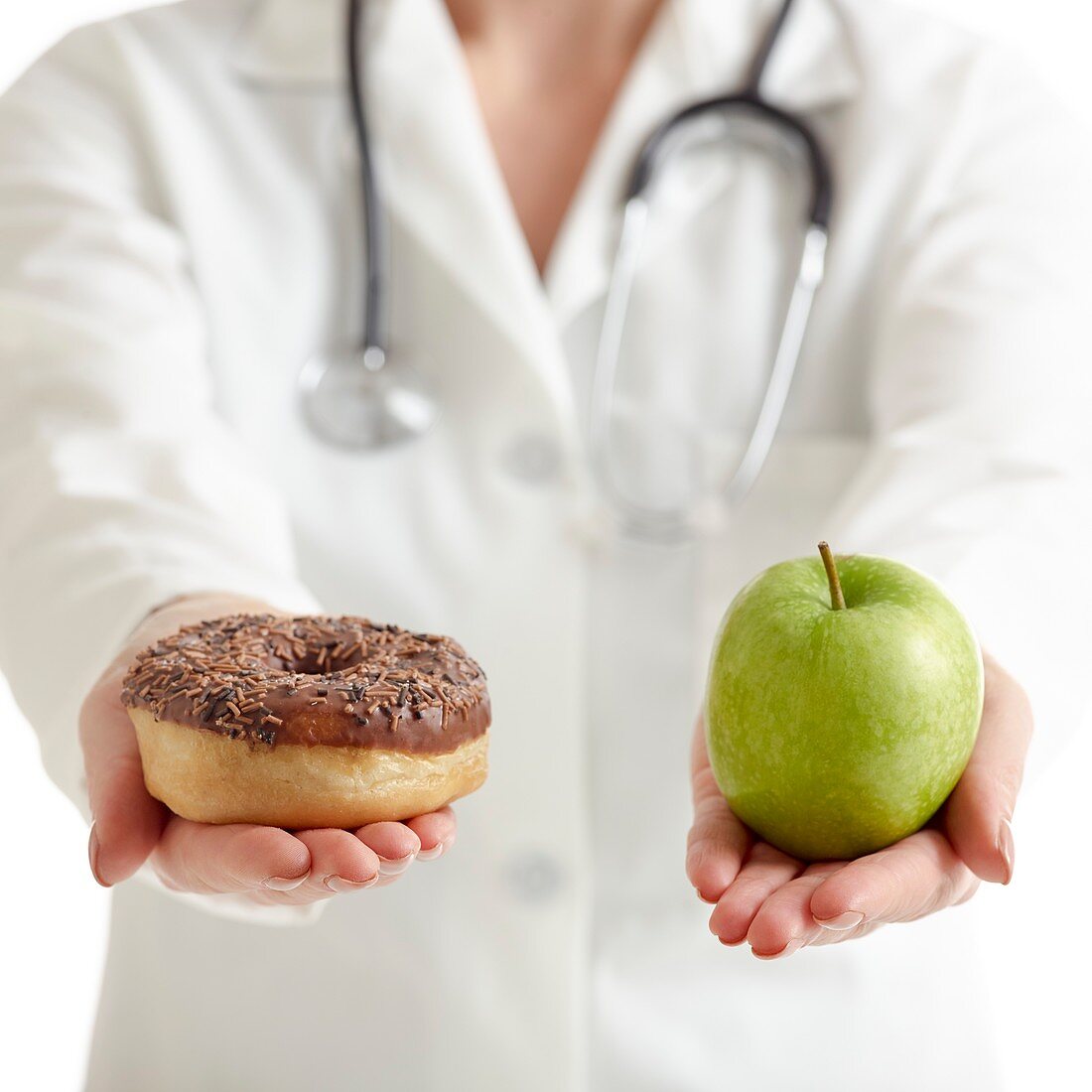 Doctor holding an apple and a doughnut
