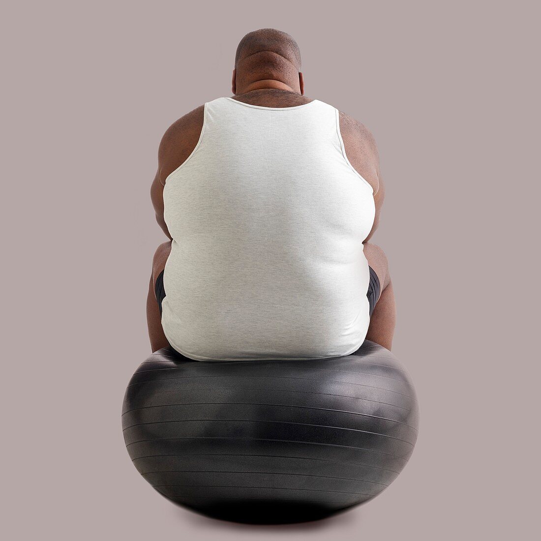 Overweight man sitting on an exercise ball
