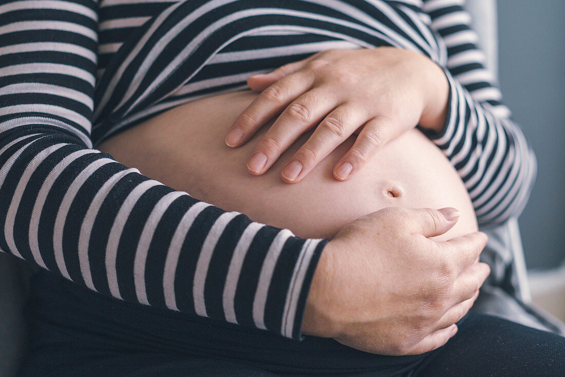 Pregnant woman with hands on abdomen