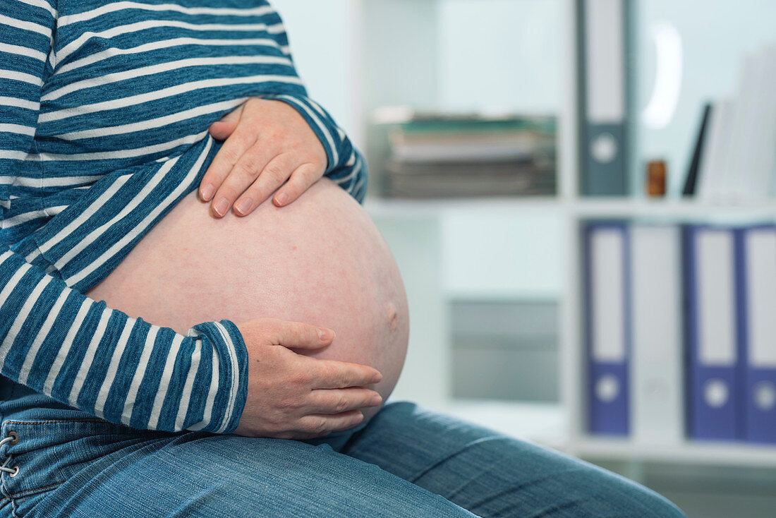 Pregnant woman with hands on abdomen