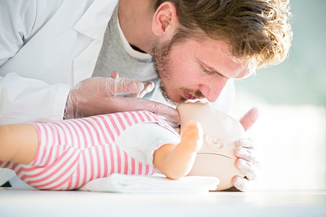 Doctor practising infant CPR