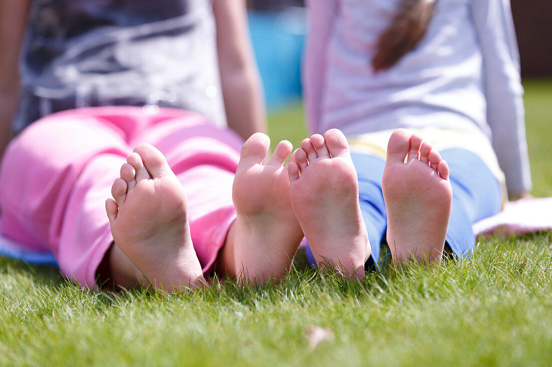 Girls' bare feet on grass