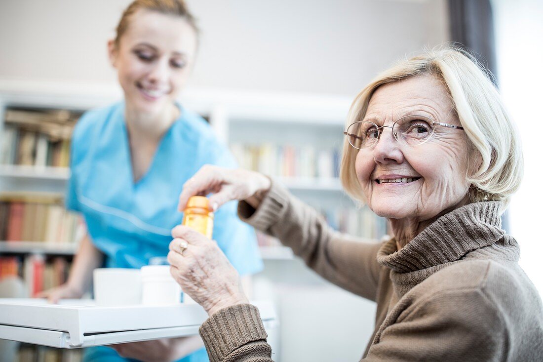 Woman opening medicine bottle and smiling