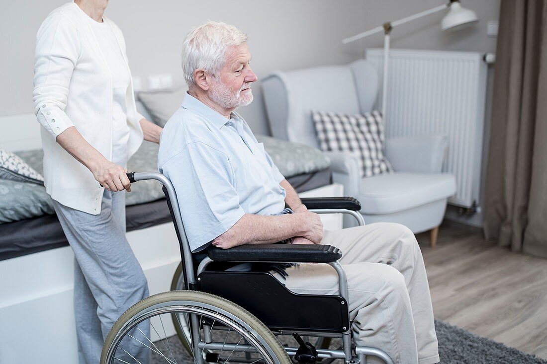 Senior man in wheelchair with woman