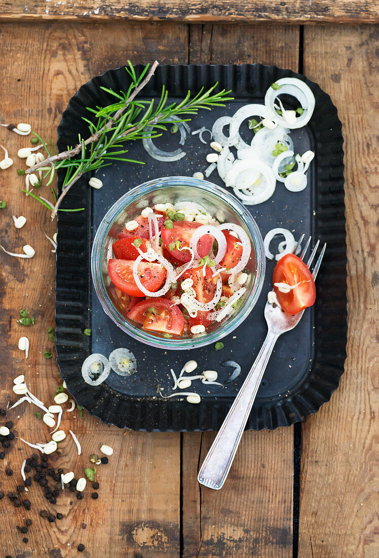 Tomatensalat mit Zwiebelringen und Sprossen im Glas