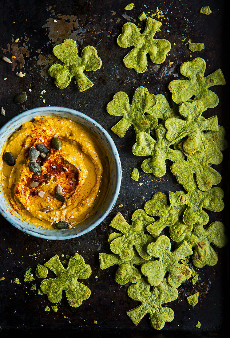 Bowl of morrocan spiced hummus dip with spinach tortilla crisp chips