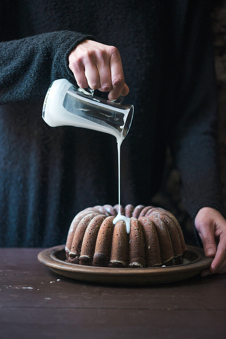 Veganen Gugelhupf mit Zuckerglasur übergiessen