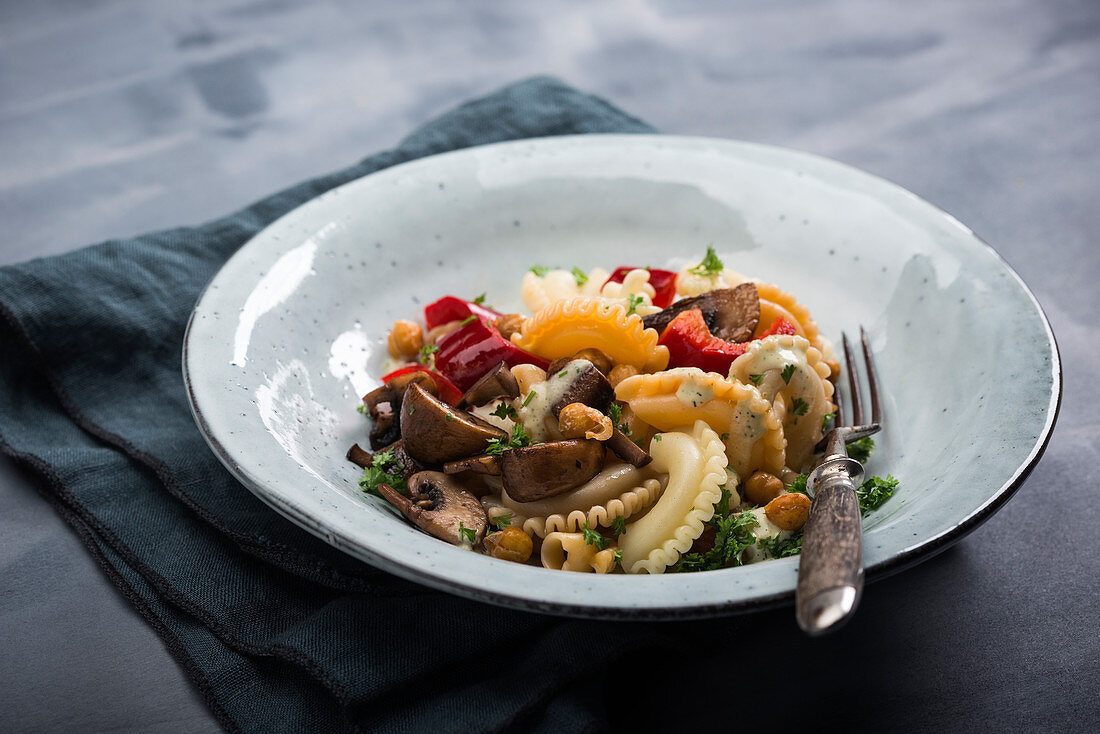 Vegan lukewarm pasta salad with peppers, mushrooms and roasted chickpeas