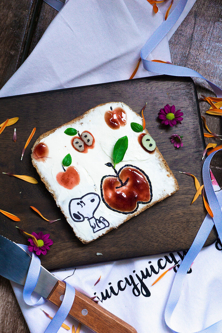 Toast with cream cheese and strawberry jam decorated with Snoopy