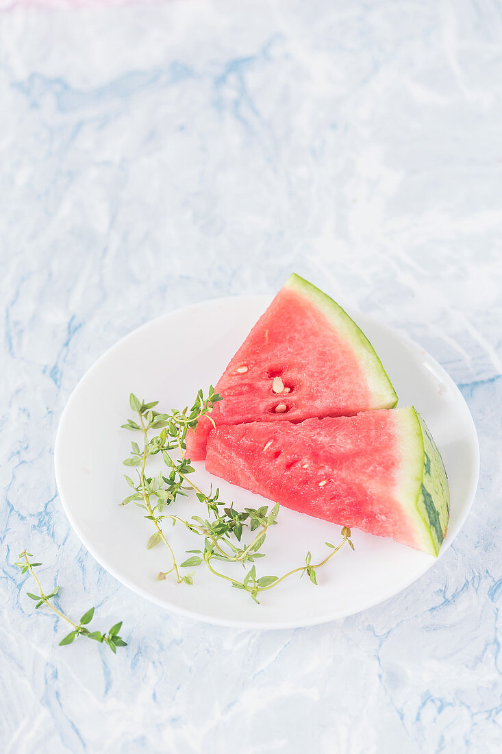 Watermelon wedges and thyme on a plate