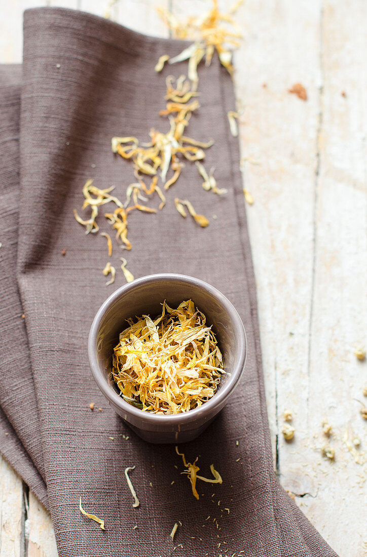 Edible yellow flowers in a bowl and a linen cloth