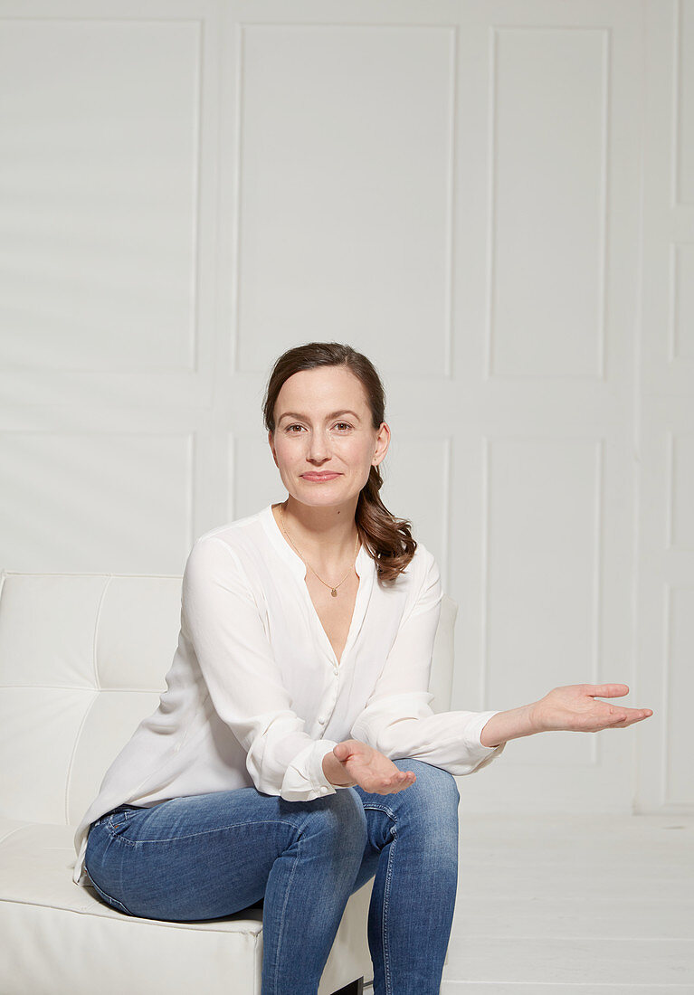 A woman sitting down with her hand turned palm up