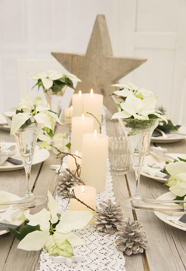 Weihnachtlicher Tisch mit Holzstern und Spitzenband, Koniferengrün