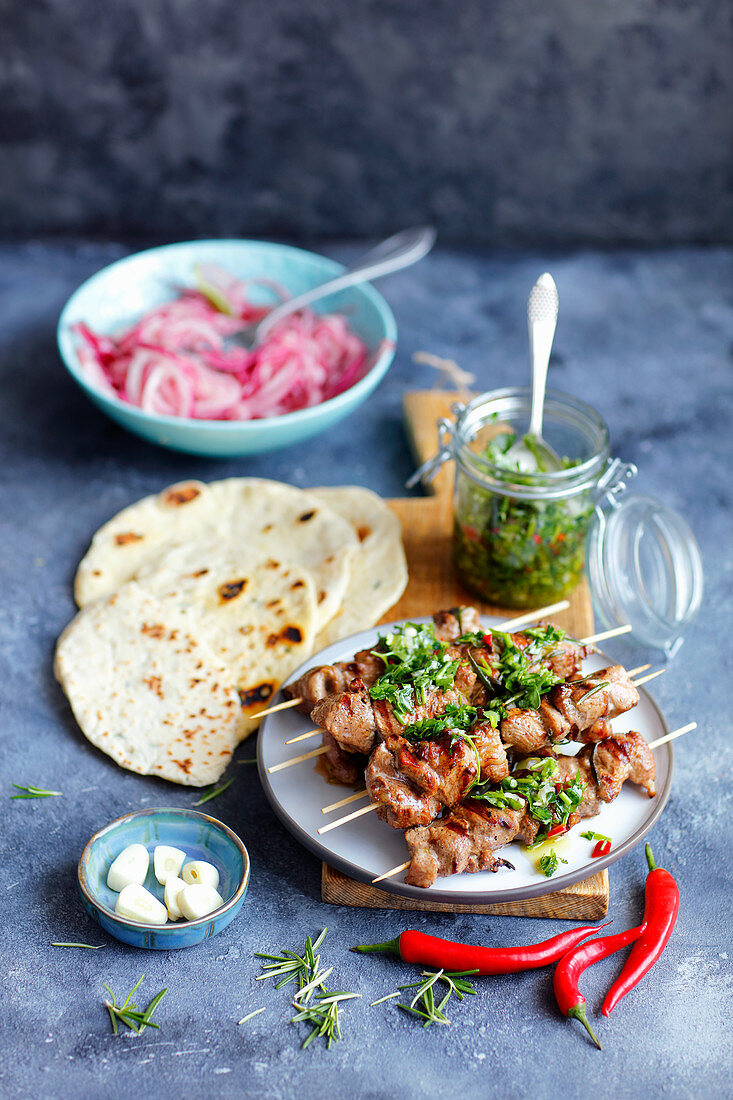 Beef skewers with flatbread, gremolata and pickled onion
