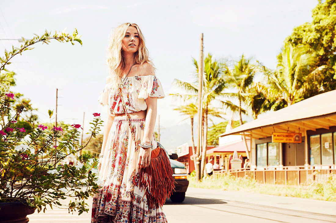 A young woman wearing a Bohemian off-the-shoulder blouse and a matching skirt