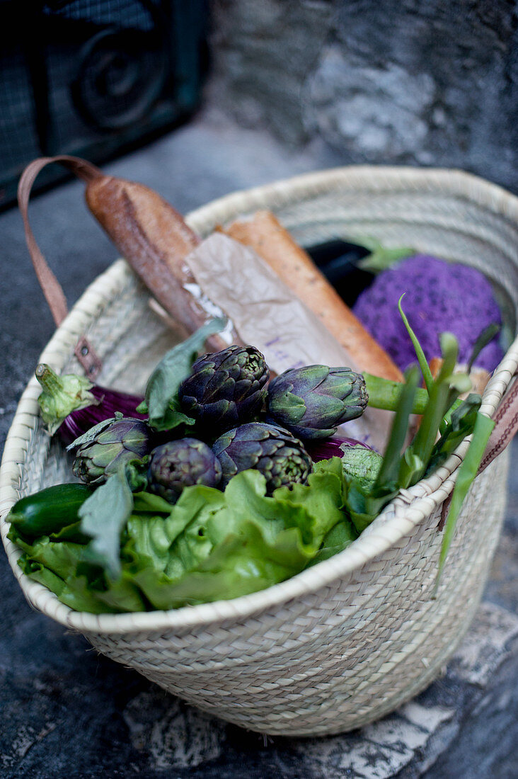 Artischocken, Salat und Baguette in Korbtasche