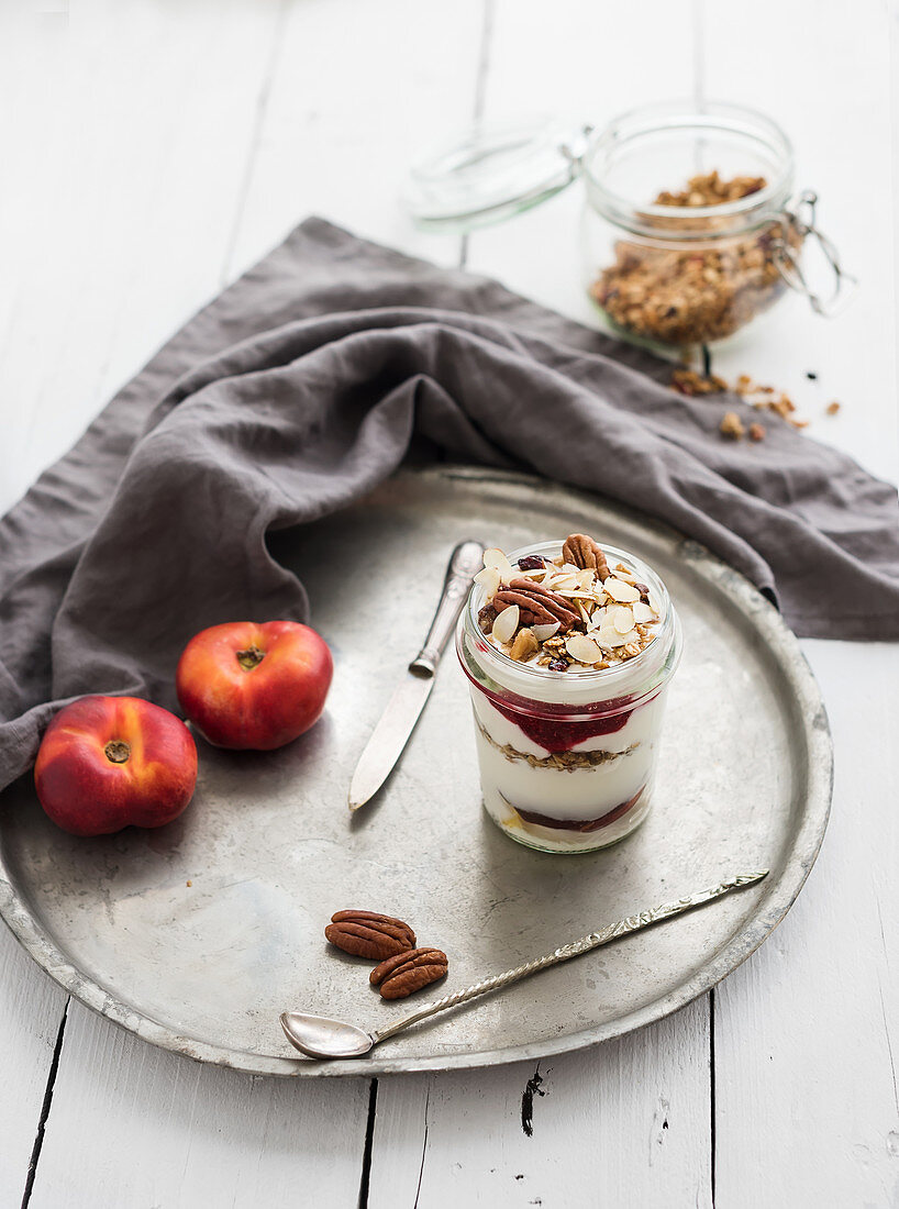 Yogurt oat granola with berries, honey, nuts and nectarins