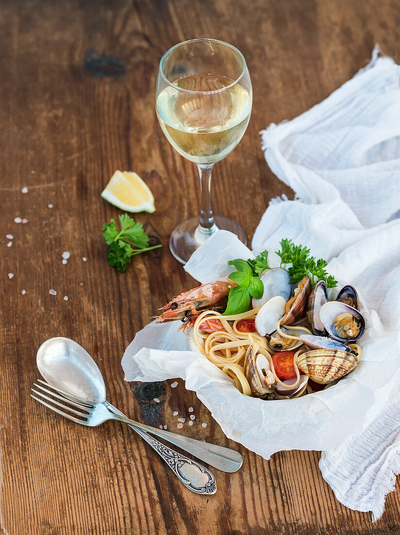 Spaghetti mit Meeresfrüchten serviert mit einem Glas Weißwein