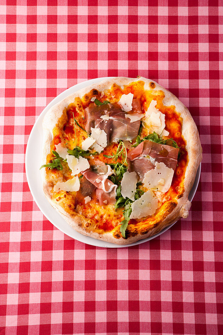 Pizza mit Parmaschinken, Parmesan und Pilzen