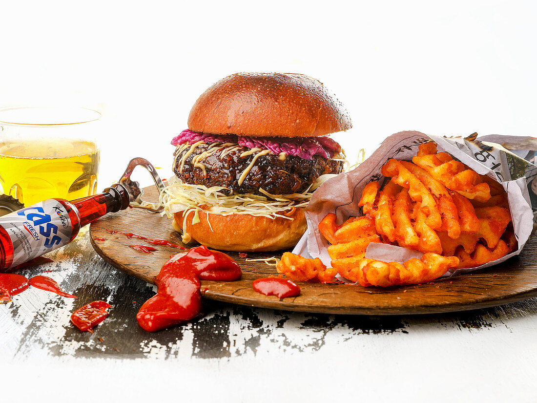 Koreanischer Hamburger mit Pommes auf Holzbrett