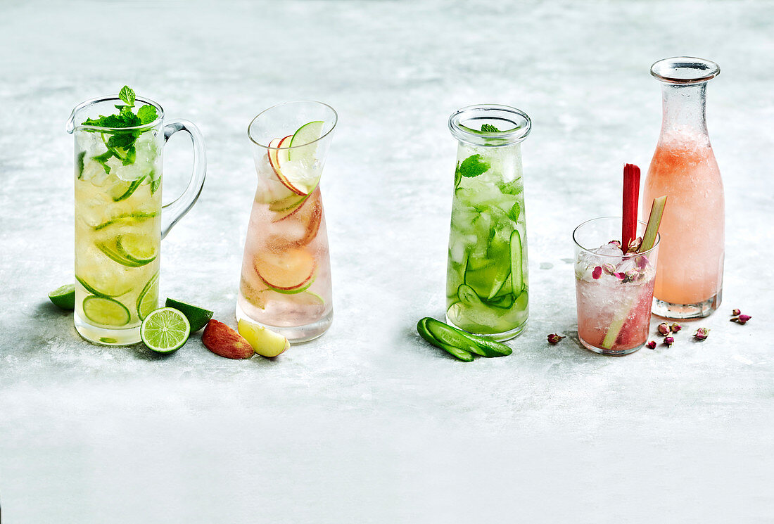 Verschiedene alkoholfreie Drinks mit Limette, Apfel, Gurke und Cranberries