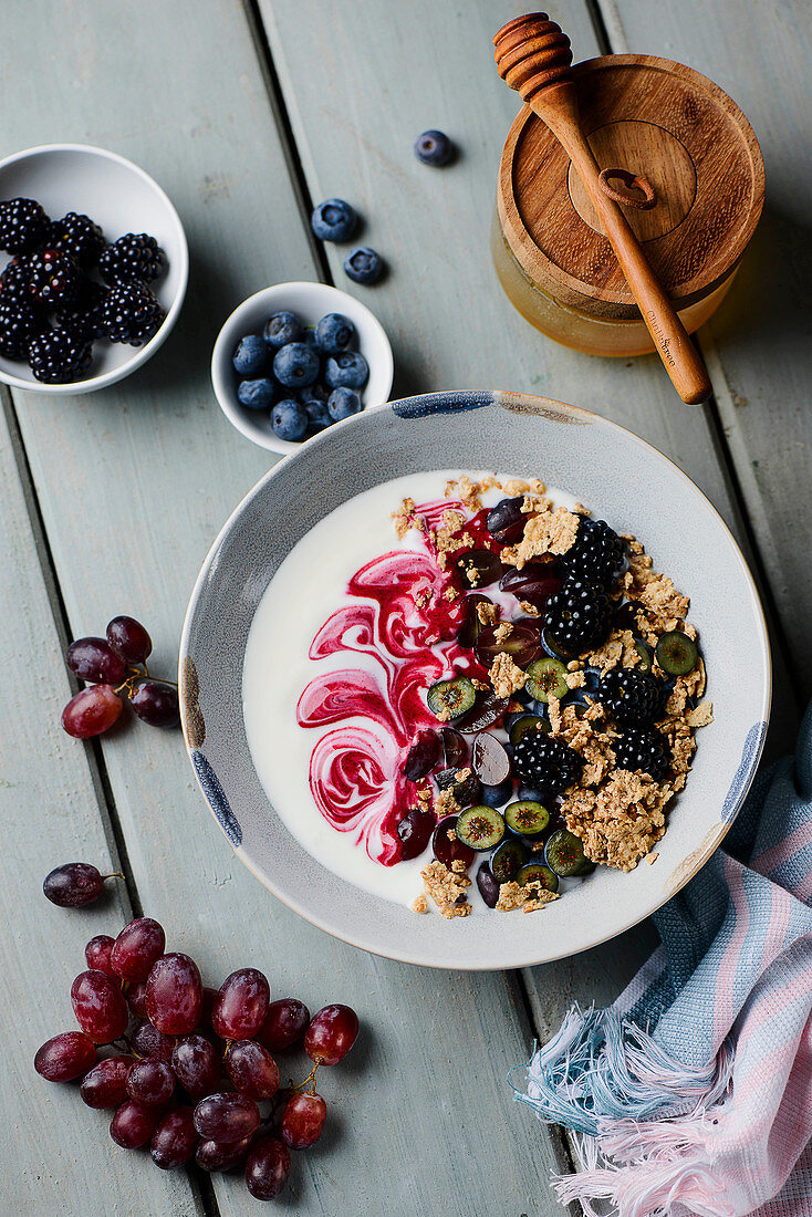 A yogurt bowl with wholegrain oatmeal, berries and grapes