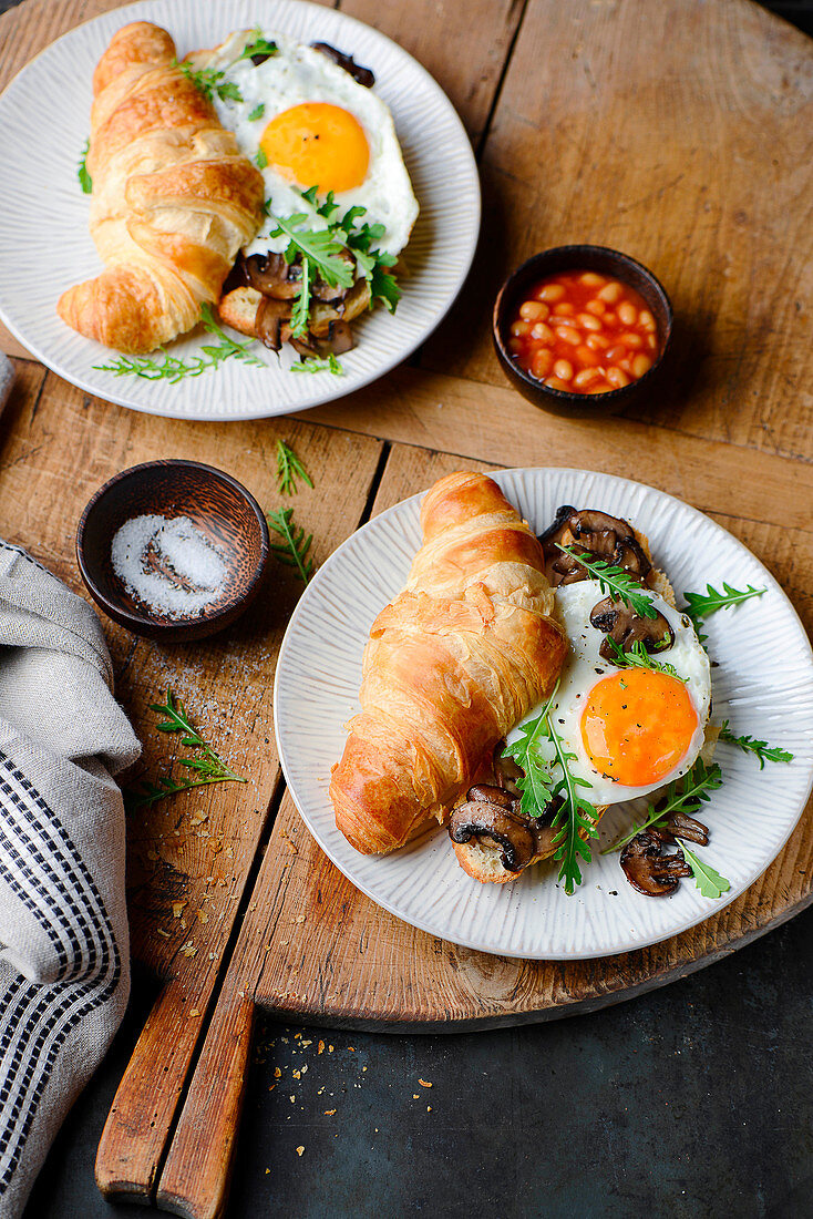 Croissant-Sandwich mit Spiegelei und Pilzen