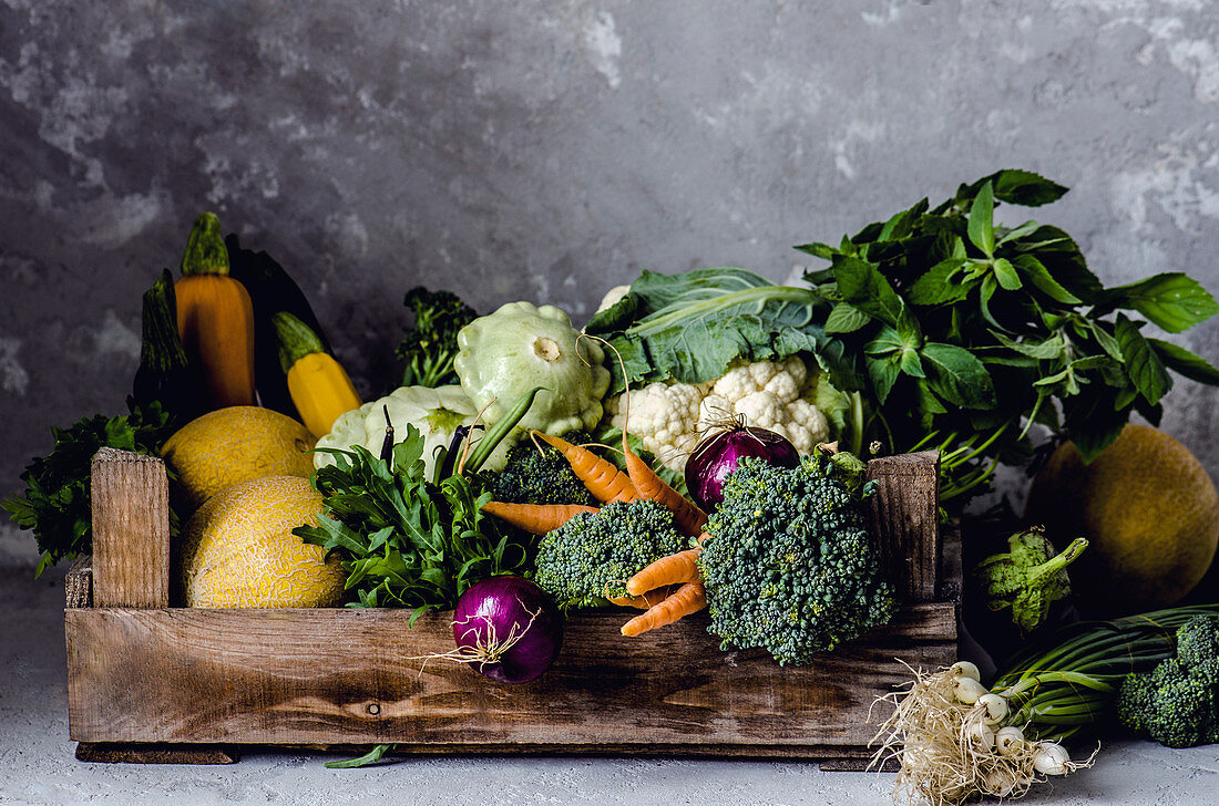 A vegetable box with cabbage, onions and pumpkin