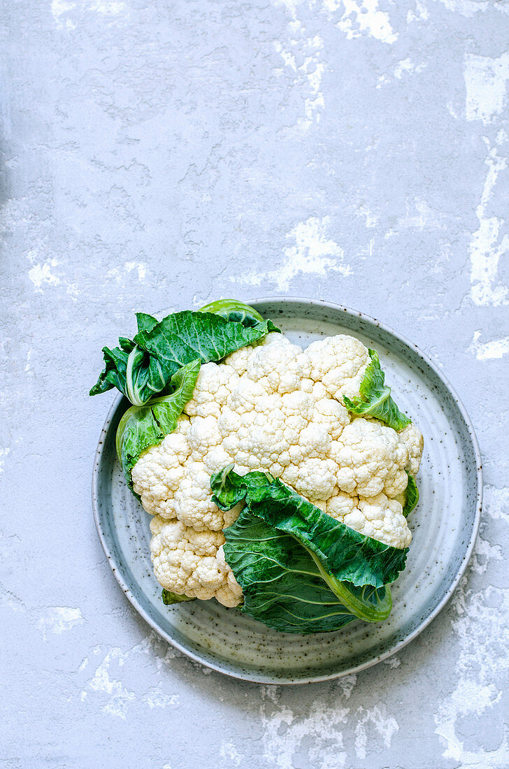 A fresh cauliflower on a ceramic dish