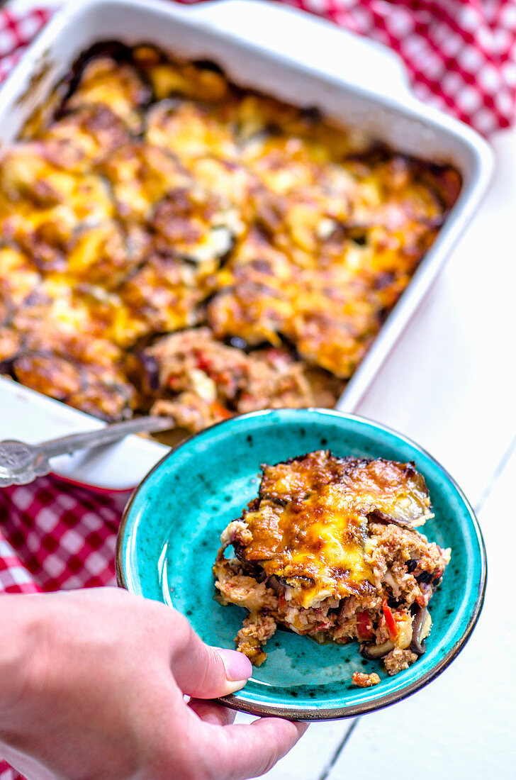 Moussaka on a plate and in a baking dish