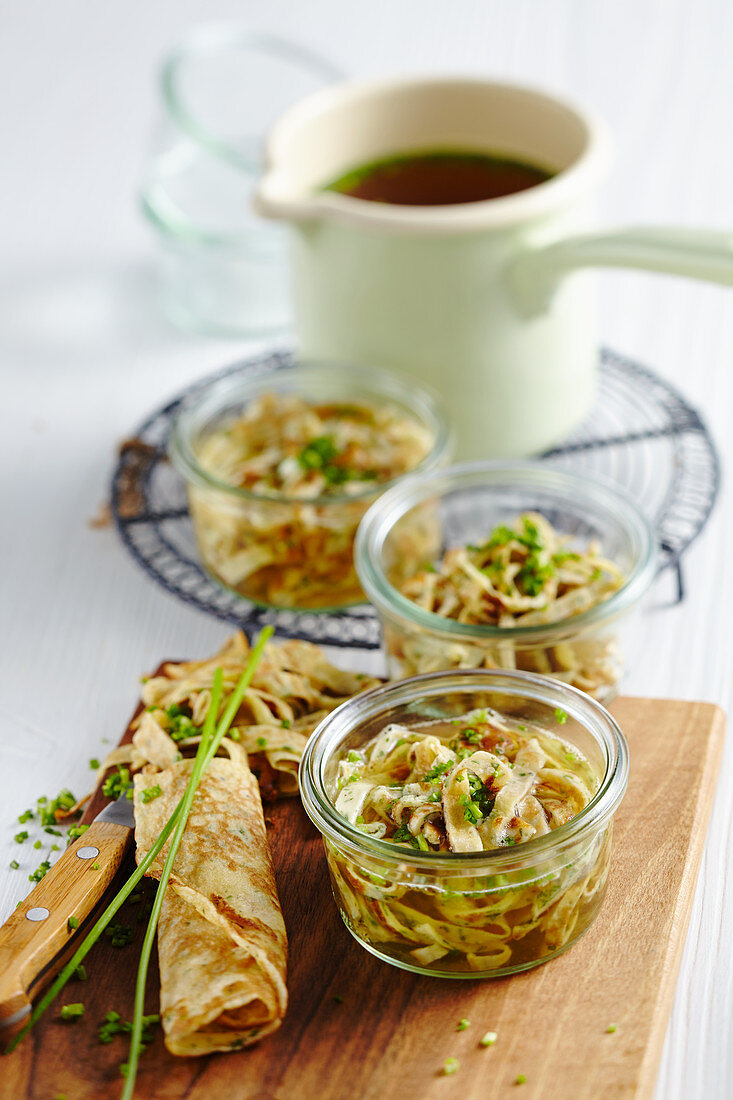 Clear meat broth in jars served with pancake strips