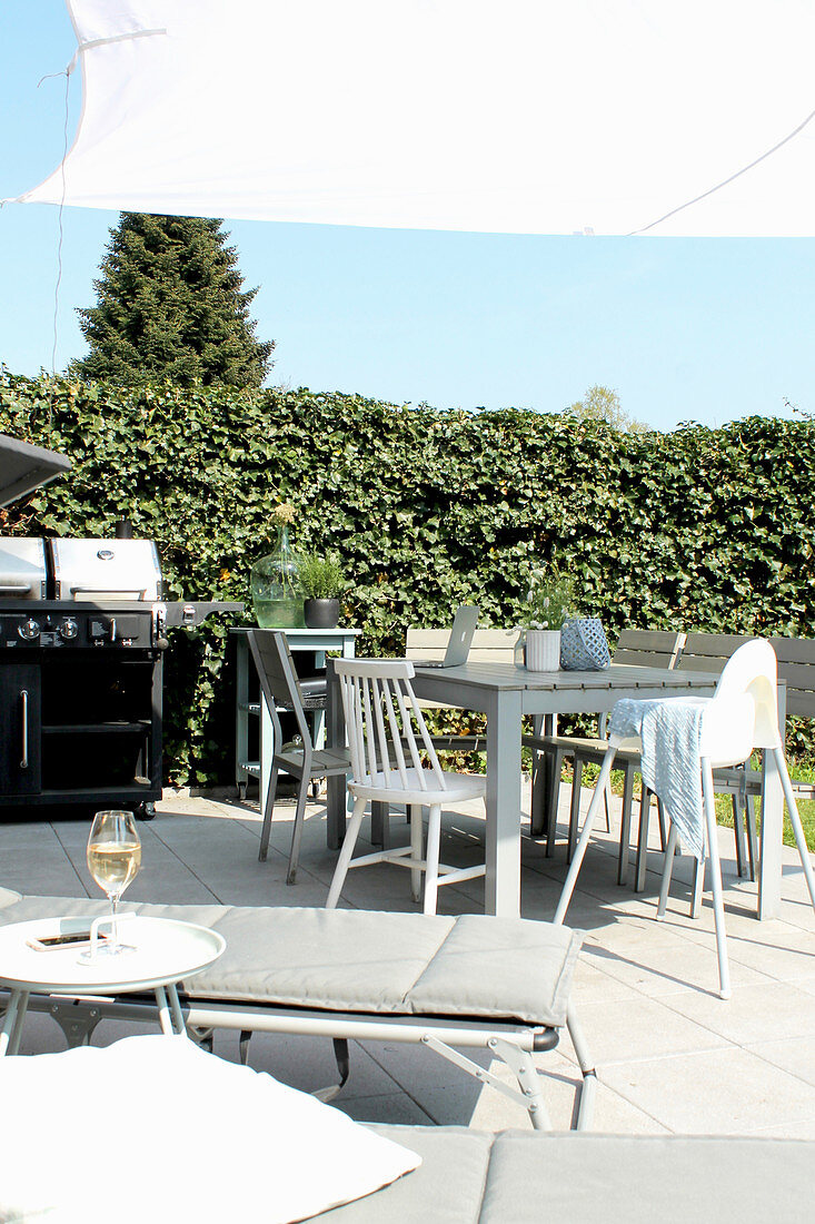 View past loungers to table, chairs and barbecue on terrace