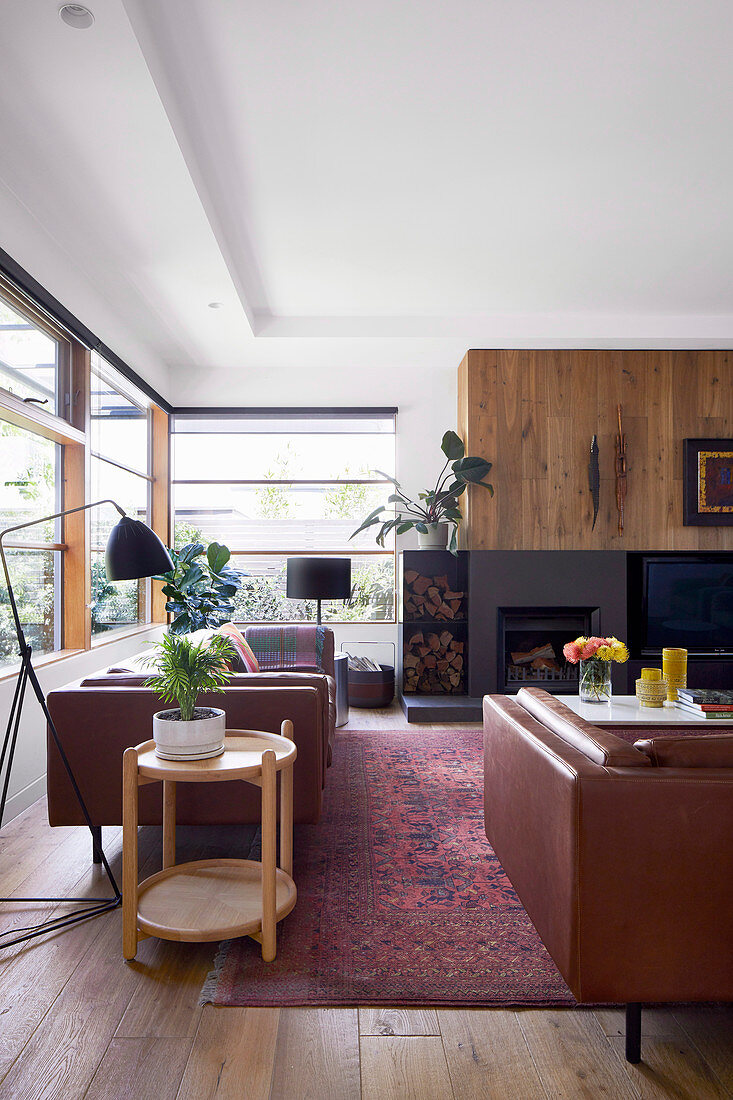 Living room in warm tones with a window front and fireplace