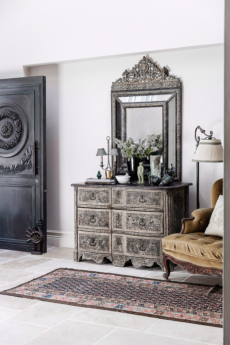 French chest of drawers and mirror in the hallway with antique door