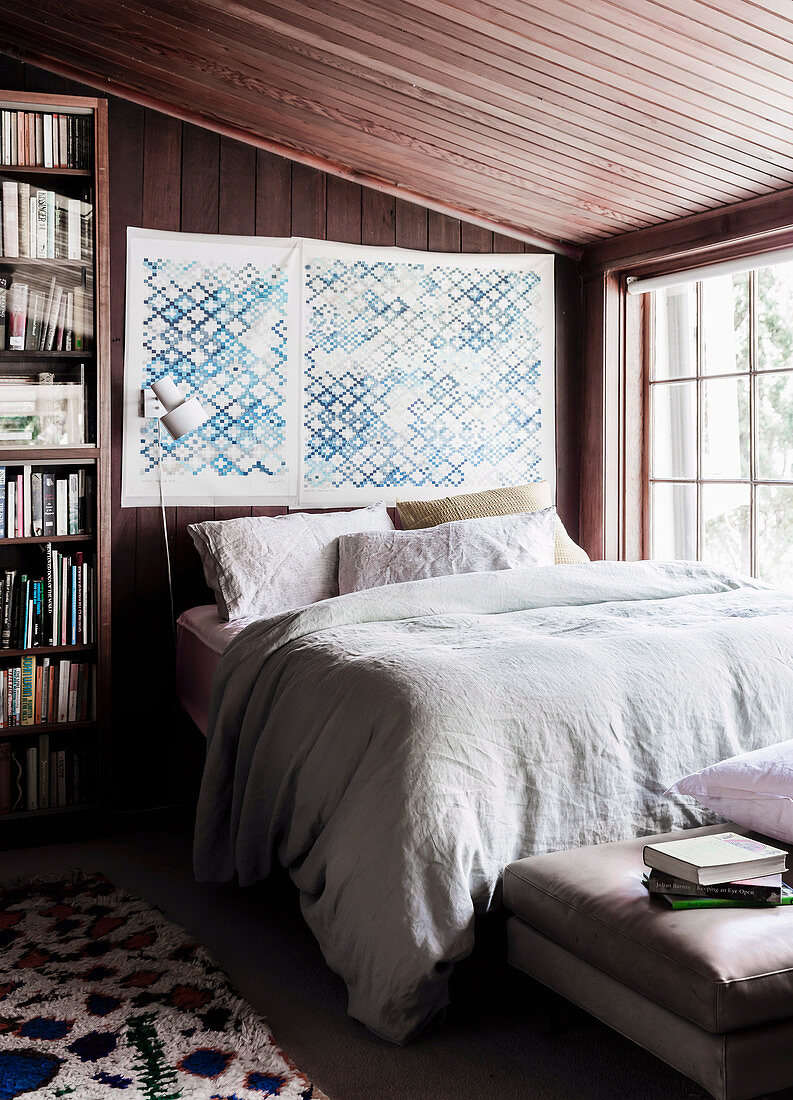 Double bed in the bedroom with dark wood paneling