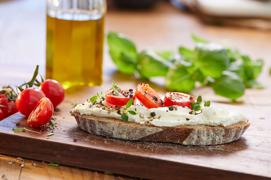 A slice of bread topped with cream cheese, tomatoes and cress