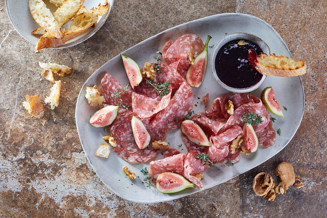 A salami platter with figs and walnuts