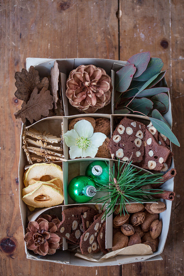 Naturdeko, Haselnussgebäck und Weihnachtsdeko in einer Schachtel