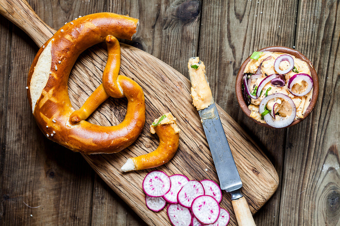 Obatzda (Bavarian cheese spread) with onions, radishes and spring onions, and a pretzel