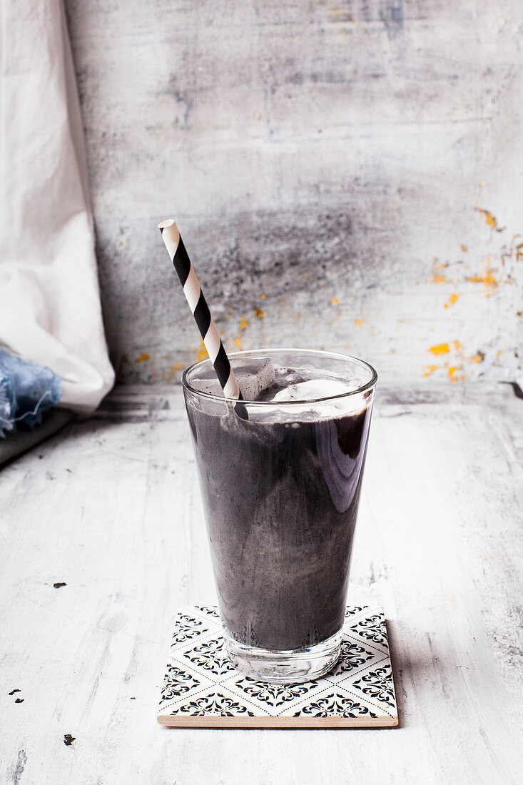 Vegan milkshake with coconut milk, charcoal and ice cubes