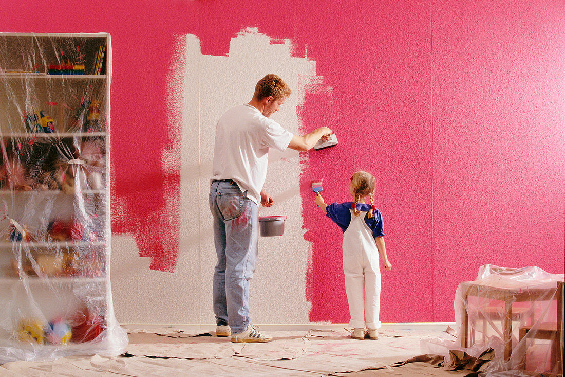 A father and daughter painting a bedroom