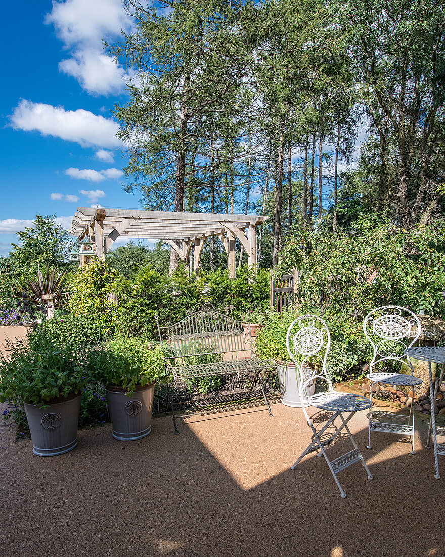 Metal table and chairs in garden on edge of woods