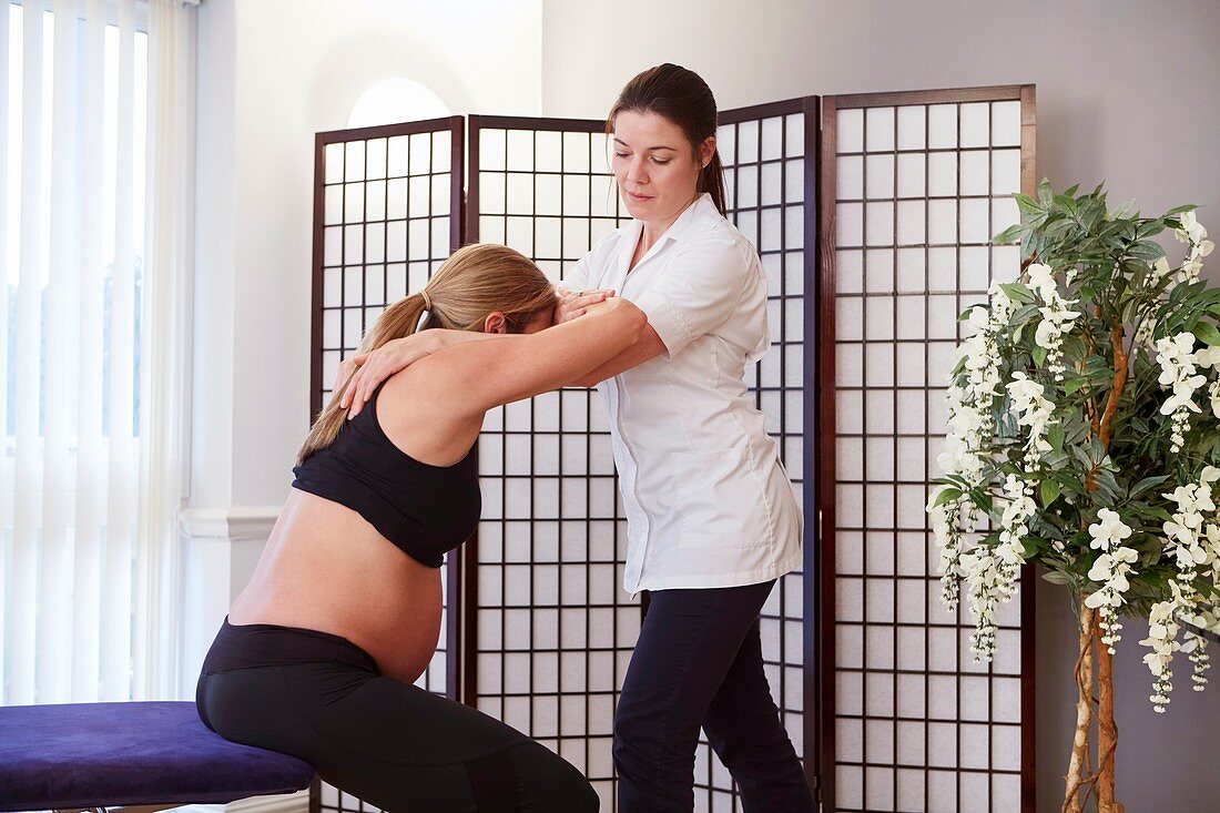 Pregnant woman being treated by an osteopath