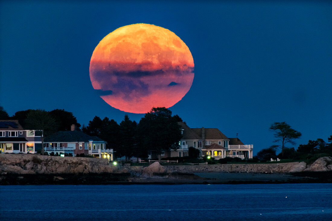 Full moon rising over oceanfront houses