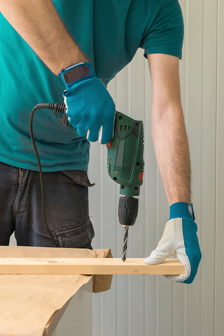 Carpenter using electric drill