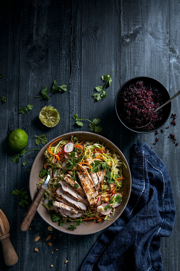 Asiatischer Krautsalat gegrilltem Hühnchen und rotem Reis