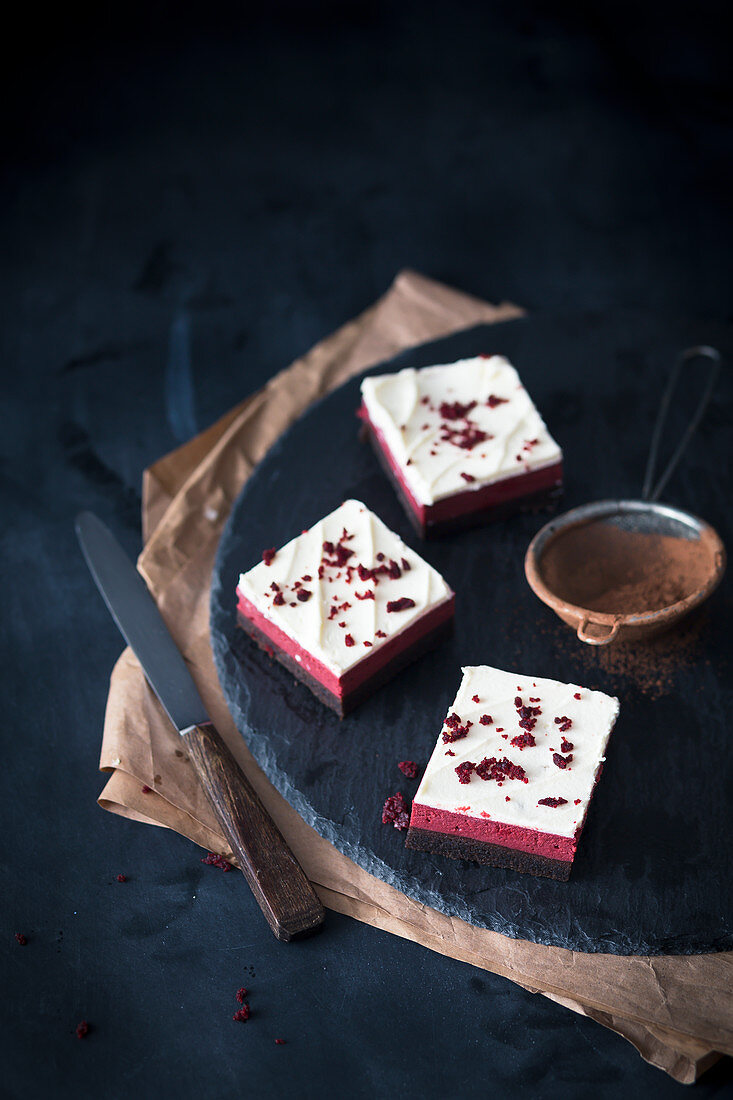 Red Velvet cheesecake brownies on a slate platter