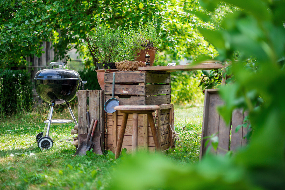 A garden kitchen with a round grill in a summer garden