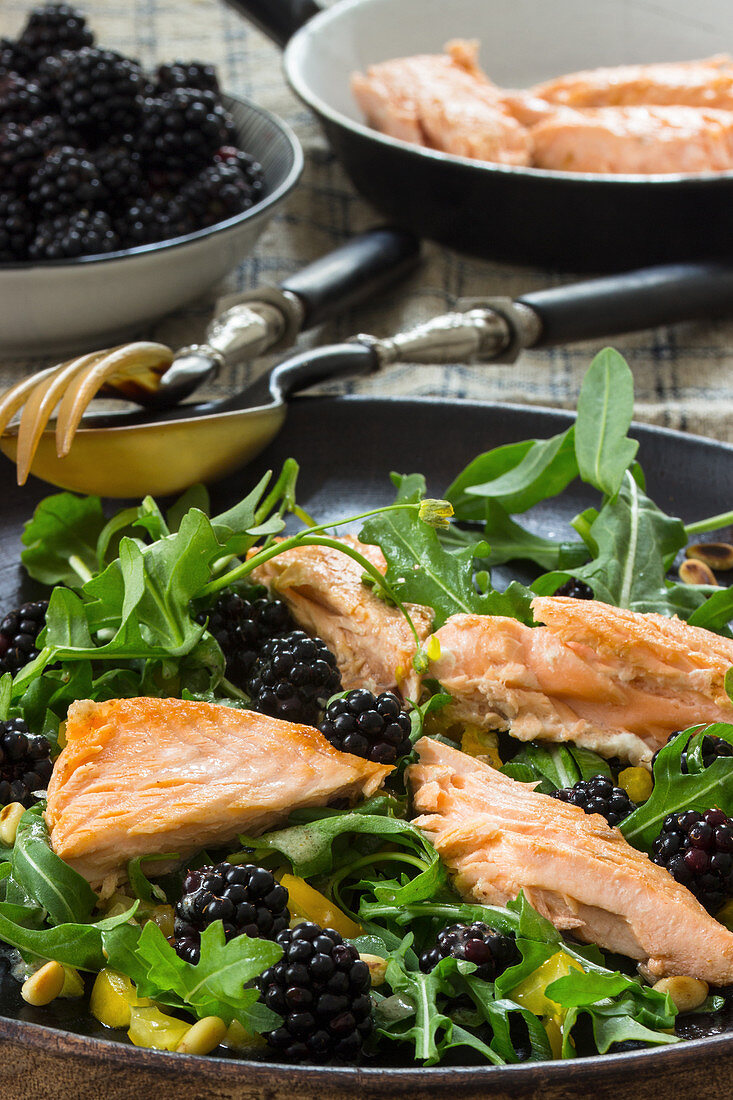 Rocket salad with blackberries, roasted salmon fillet and pine nuts